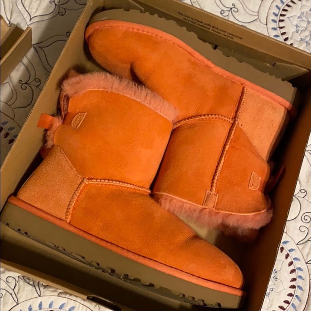 Women’s mini bailey bow II Ugg boots in coral.